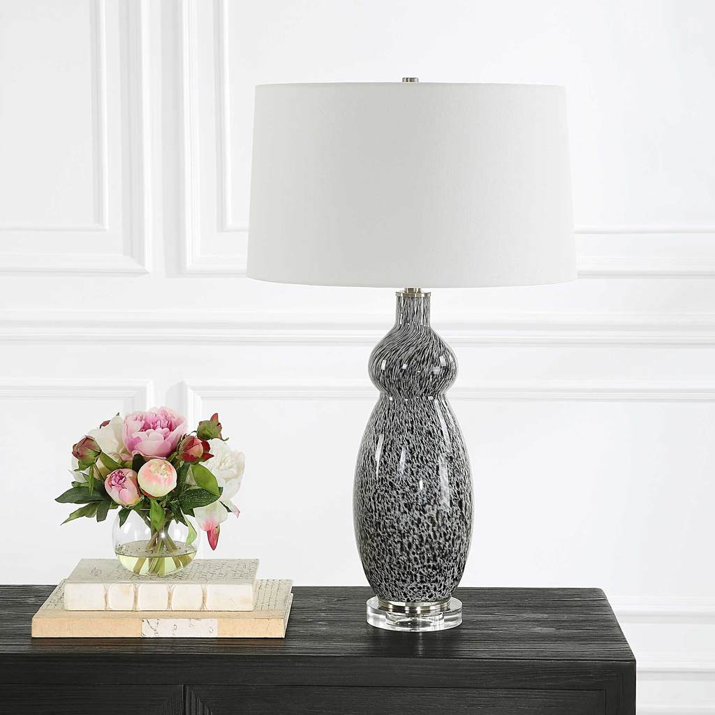 Decorative View. The Velino Curvy Glass Table Lamp base features a soft gray background with mottled