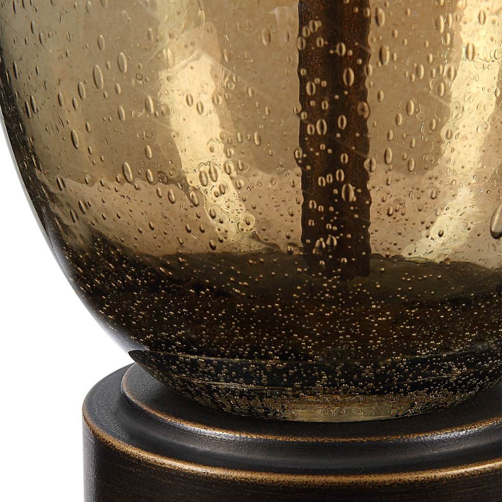Close-Up View. The Baltic Table lamp showcases a dark amber, teardrop glass base accented with rusti